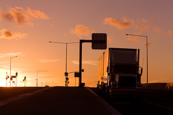Trucks and traffic on Western Ring Road at sunset