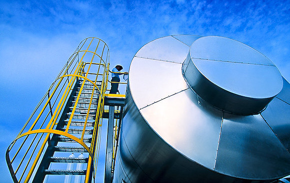 Workman performing service and mainenance on gas tanks