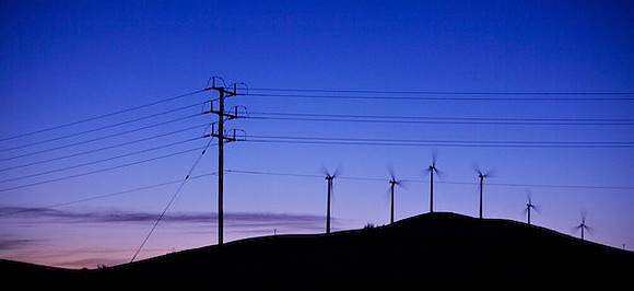 Wind turbines on a hill rise silhouetted against sunset sky in Western Victoria