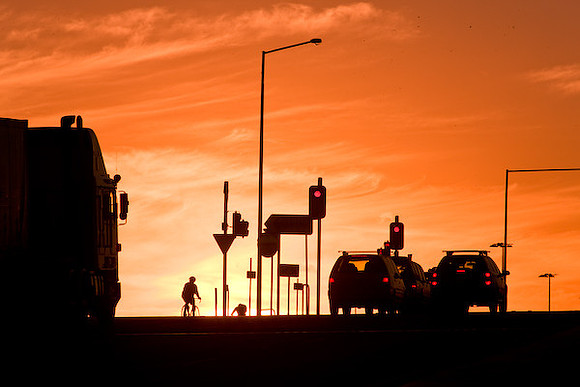 Trucks and traffic on Western Ring Road at sunset